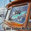 Turquoise Sardis Life sticker on a wooden boat window with Lake Lodge Media logo.