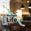 Maligne Life text overlaying a turquoise geographic outline on a glass surface.