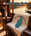 Tapestry blanket with teal Lake Derwentwater map and compass design on a couch.