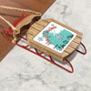 Red wooden sled ornament with "Merry Christmas from Lake St. Clair" text.