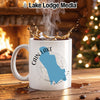 White mug with a blue map outline of Cain Lake, Washington and steaming coffee.