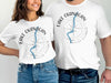 White t-shirts featuring a compass design and "Lake Okanagan British Columbia" text.