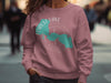 Rose pink crewneck sweatshirt with Forest Lake Minnesota map and compass graphic.