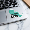 Teal Sandhill Life sticker on a laptop keyboard with a marble background.
