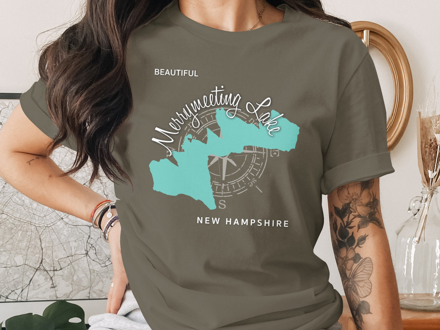 Olive green t-shirt featuring Merrymeeting Lake, New Hampshire, and a compass rose graphic.