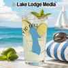 Glass with drink, lime, mint, and sunglasses on a beach with a sailboat.