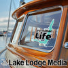 Vermillion Life sticker on a wooden boat window and Lake Lodge Media text.