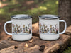 White enamel mugs with a winter fishing scene and the word "Lake" adorned with holiday lights.