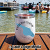 A white insulated wine tumbler with a Catalina Island map graphic rests on a wooden dock with people in a lake background.