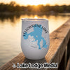 A white insulated wine tumbler featuring a blue map graphic of Yellowstone Lake and text sitting on a wooden dock at sunset.