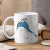 White mug with blue Bow Lake silhouette, compass graphic, and text.