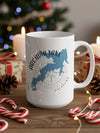 White mug with Arcadia Lake, Oklahoma map and compass design among Christmas decorations.