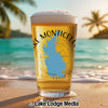 Glass of beer with "Lake Monticello" and blue lake outline on beach.
