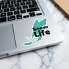 Turquoise sticker with black text "Snow Life" on a laptop.