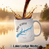White mug with "Lake Icaria Iowa" map and compass design, coffee pouring.