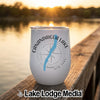 A white tumbler featuring a compass design, Canandaigua Lake map, and text resting on a wooden dock.