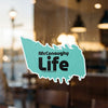 McConaughy Life sticker on a glass surface with blurred interior background.