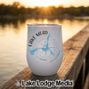 A white stemless wine tumbler with Lake Mead graphics rests on a wooden dock at sunset.