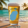 Glass of beer with "Lake Pulaski" and a lake outline on a beach.