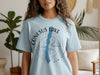 Light blue t-shirt with "Conesus Lake New York" text and a compass graphic.