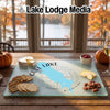 A glass cutting board featuring a map of Gull Lake, Michigan rests on a wooden table.