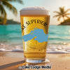 Glass of beer with "Lake Superior" text and map of Lake Superior on a beach.
