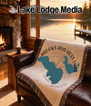 Woven blanket with Brooks and Hess Lake Michigan map design on a sofa.
