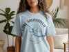 Light blue t-shirt with Lake Sakakawea compass design and North Dakota text.