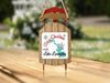 Sled ornament with "Merry Christmas FROM Lake Livingston" text and turquoise lake shape.