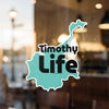 Turquoise sticker with "Timothy LIFE" text, adhered to a window.