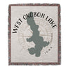 Woven throw blanket featuring West Okoboji Lake shape, compass rose, and text.