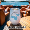 A white insulated wine tumbler with a compass and lake design sits on a wooden boat table.