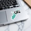 Sacandaga Life sticker on a laptop keyboard with lake silhouette and text.