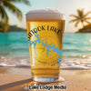 Glass of beer on a beach with "ATOKA LAKE" and compass graphic.