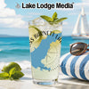 Tall glass with drink, limes, mint, and "SS Barnett Lake" design on beach background.