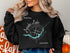 Black sweatshirt with "Beautiful Apache Lake Arizona" and compass rose design.