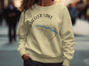 Light yellow sweatshirt with Wheeler Lake Alabama map and compass graphic.