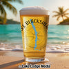 Glass of beer with "Lake Blackshear Georgia" and compass graphic on a beach.