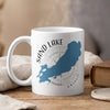 White mug with Sand Lake Ontario map and compass design, emitting steam.