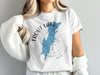 White t-shirt with blue Trout Lake, New York map, compass design.