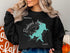 Black sweatshirt with teal map of Brook Lake, compass, and "Texas" text.