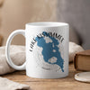 White mug with blue Lake Kissimmee map and compass design, rising steam.