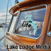 Glenville Life sticker on a wooden boat window, "Lake Lodge Media" text below.