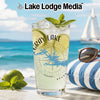 Glass with refreshing drink, limes, mint, and "Gray Lake" logo on beach background.