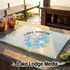 Glass cutting board featuring a blue map and the text Lake Martin, Alabama, on a wooden outdoor bar.