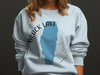 Light blue sweatshirt with black text and blue lake outline for Black Lake, Idaho.