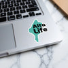Teal sticker with "Alta Life" text on a laptop keyboard.