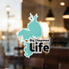 Big Chapman Life sticker on a glass window with outdoor bokeh background.