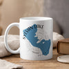 White mug with Sylvan Lake, South Dakota map and compass design, steaming.