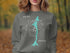Grey sweatshirt with turquoise Bear Canyon Lake map and compass design.